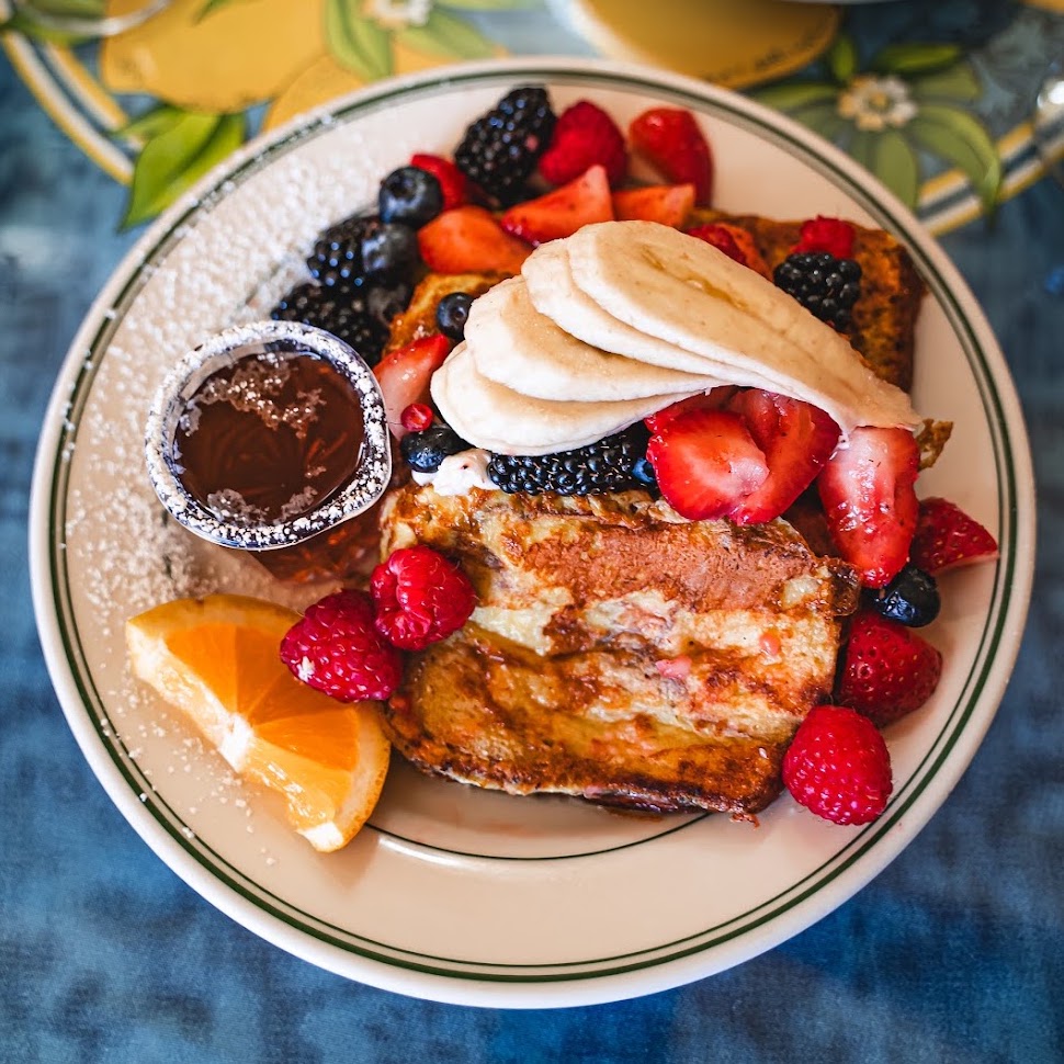 French toast sampler topped with fruit and whipped topping.