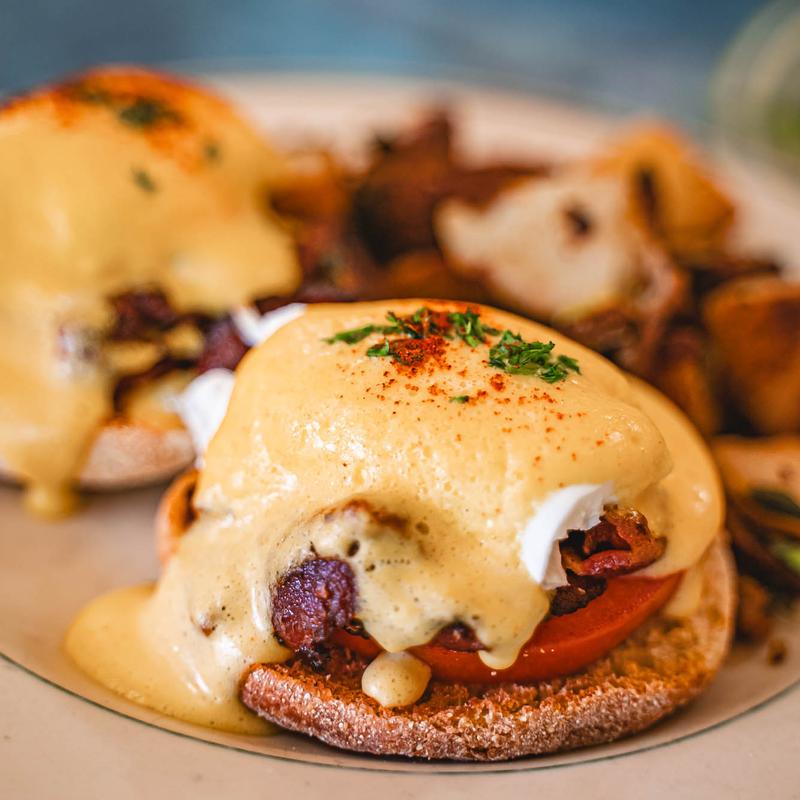 Blackstone Benedicts with crispy bacon and grilled tomato.