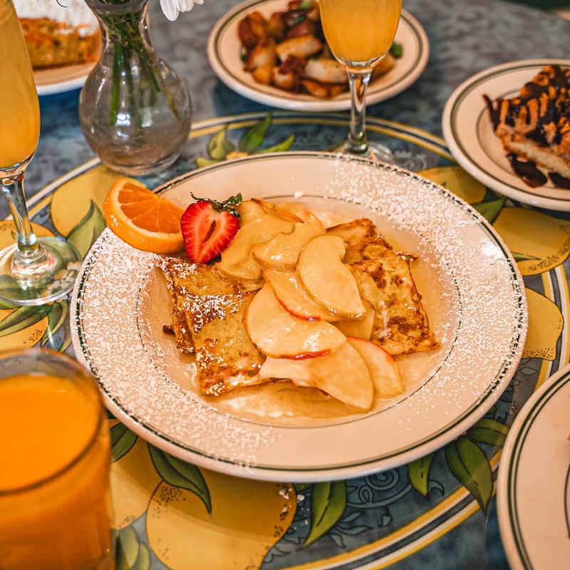 Apple Pan Dore topped with apples and powdered sugar.